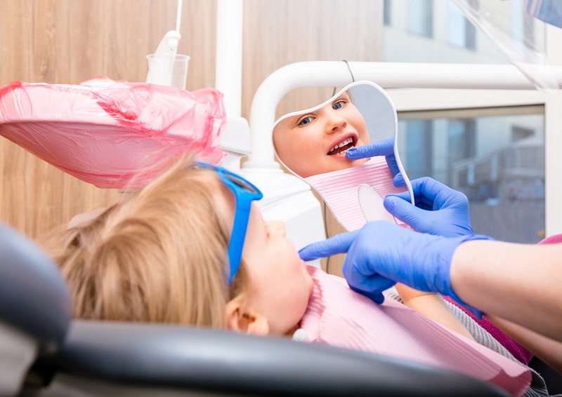 bigstock Dentist showing to little girl 296936326