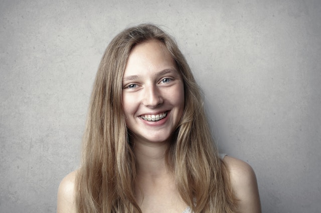 A girl with braces from an orthodontist in Ontario smiling.
